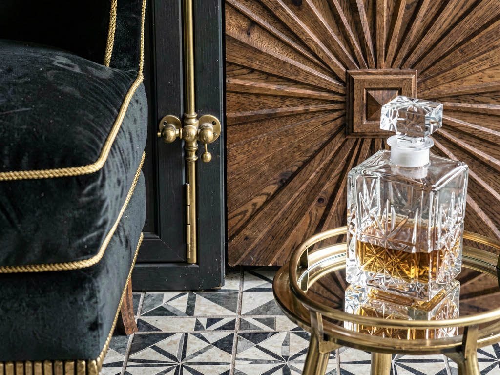 Close-up Art Deco interior design details — brass hardware, geometric tile, velvet texture
