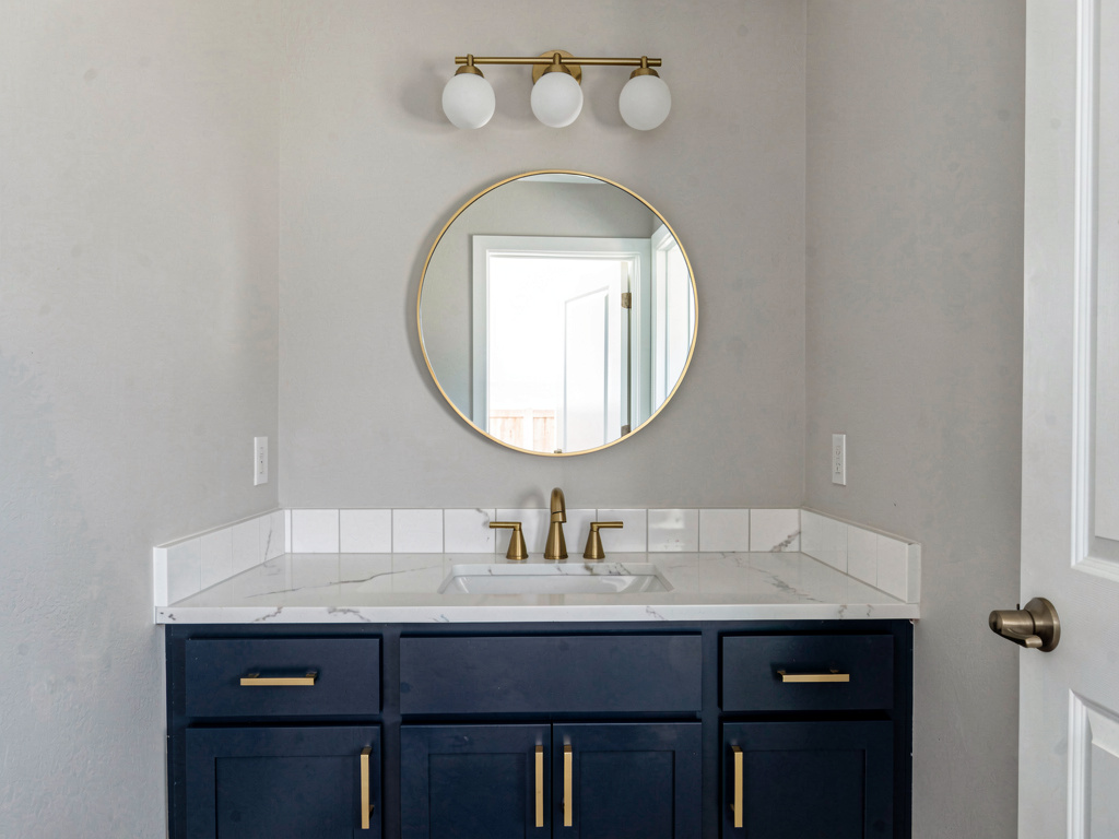 Bathroom with new painted vanity, updated brushed gold hardware and new light fixture