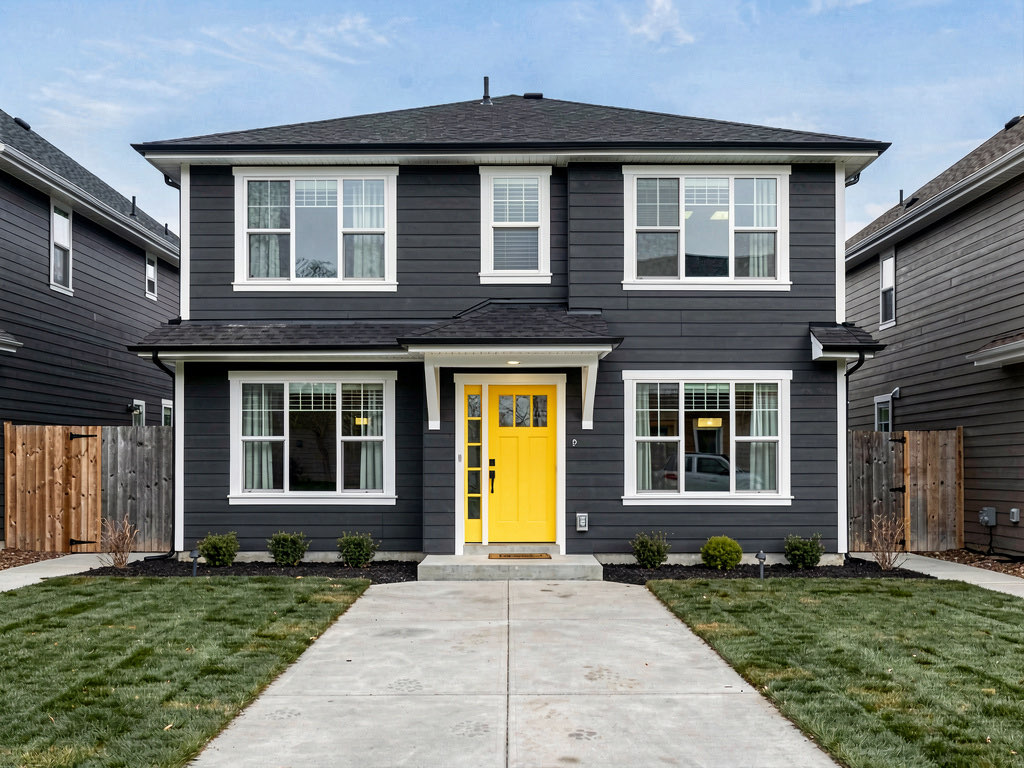 Two-story house in dark charcoal gray with bright white trim and yellow front door