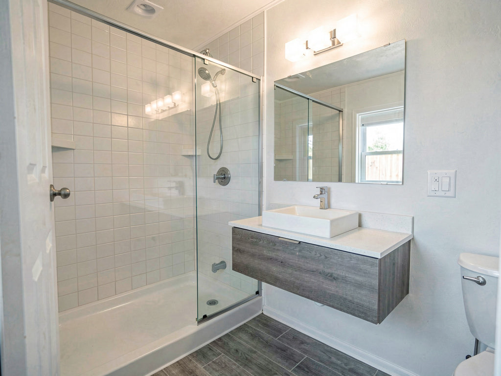 Updated mobile home bathroom with new tile walk-in shower, floating vanity and modern chrome fixtures
