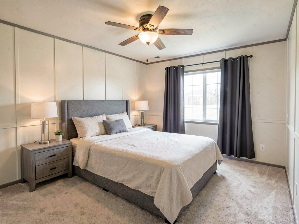 Remodeled mobile home bedroom with new drywall, warm white paint, upholstered headboard and modern lamps