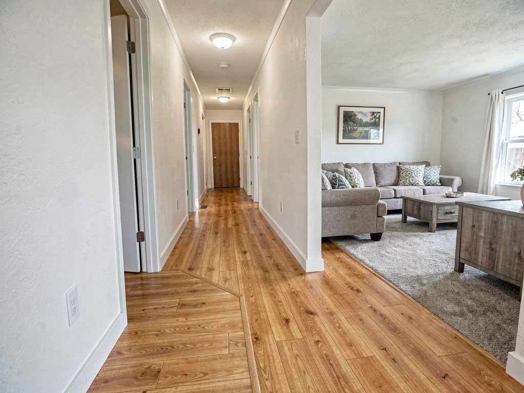 Mobile home hallway showing new luxury vinyl plank flooring in warm honey oak replacing old linoleum