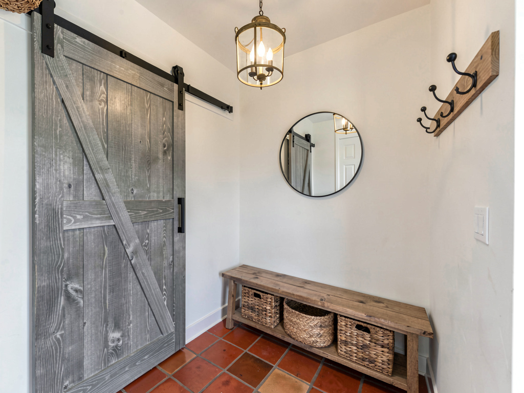 Modern farmhouse entryway with sliding barn door and wooden bench